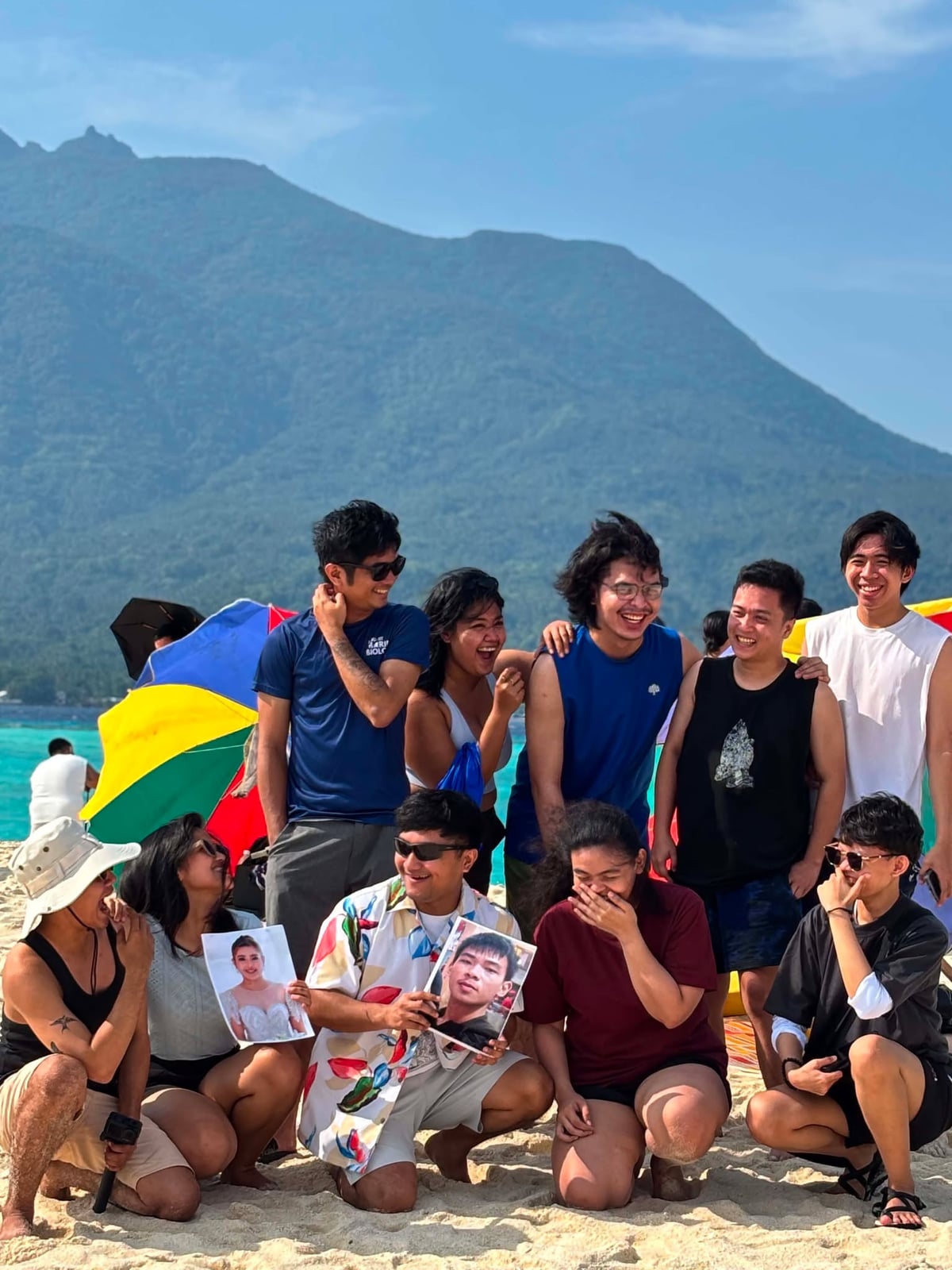 The NorthQA team on the beach with Camiguin's mountains behind them
