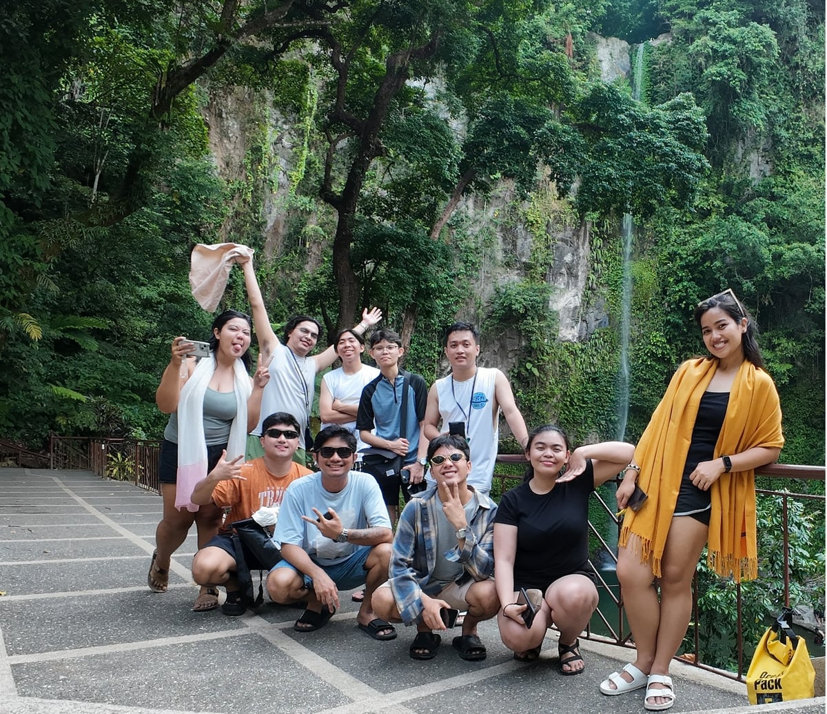The NorthQA team posing at a waterfall in Camiguin